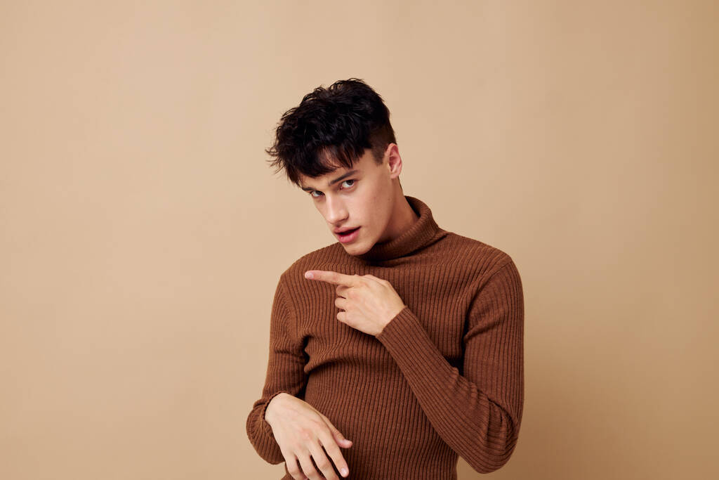 retrato de un hombre joven posando en suéter marrón confianza en sí mismo de moda Estilo de vida inalterado - Foto, Imagen