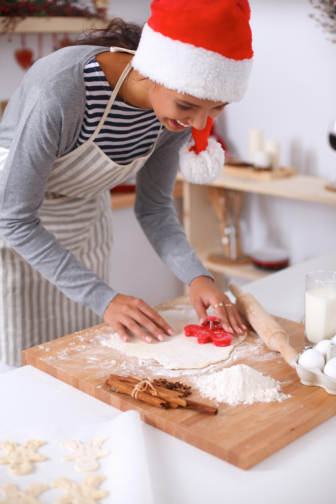Vrouw maakt kerstkoekjes in de keuken - Foto, afbeelding