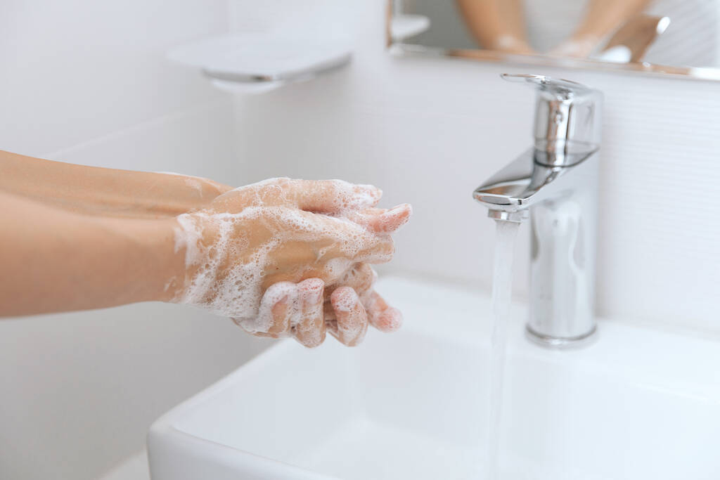 Handen wassen onder de stromende kraan. Hygiëne concept hand detail. Handen wassen wrijven met zeep voor preventie van corona virus, hygiëne om te stoppen met het verspreiden van corona virus in of openbare wasruimte - Foto, afbeelding