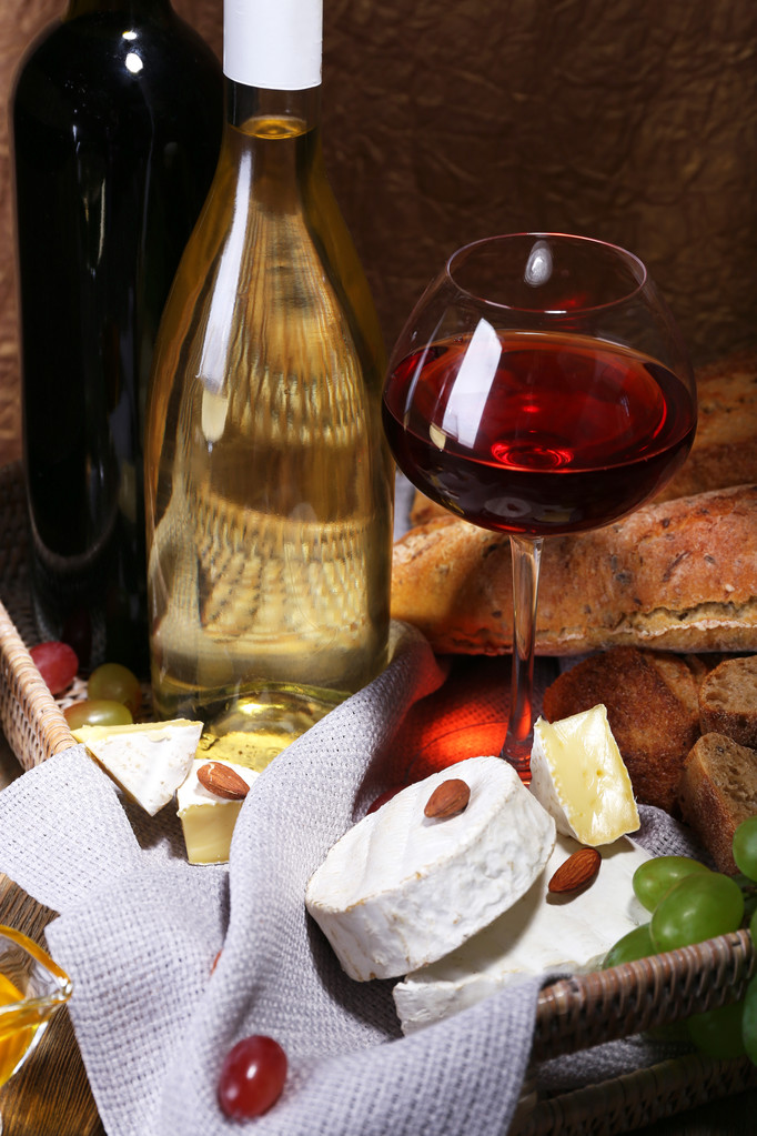 Camembert ve brie peyniri, bal, şarap ve üzüm sepeti kahverengi zemin üzerine ahşap masa üzerinde peçete üzerinde oluşan akşam yemeği - Fotoğraf, Görsel