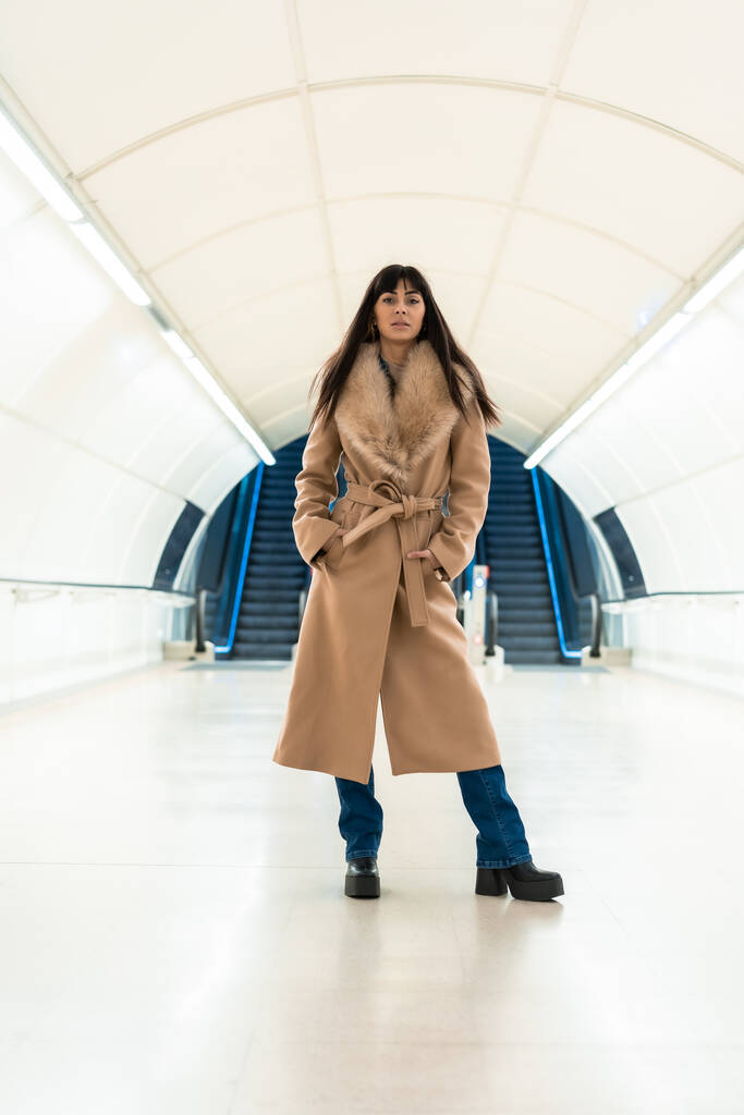 冬に地下鉄にジャケットを着たブルネットの女の子。トンネルの中を歩く白人 - 写真・画像