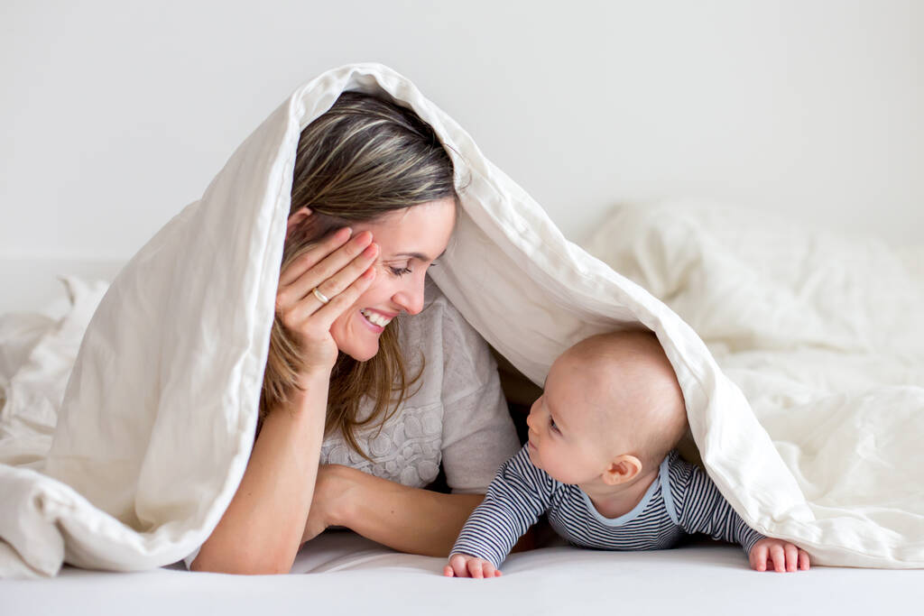 Matka i jej mały chłopczyk bawią się razem w sypialni, szczęśliwa rodzinna koncepcja - Zdjęcie, obraz