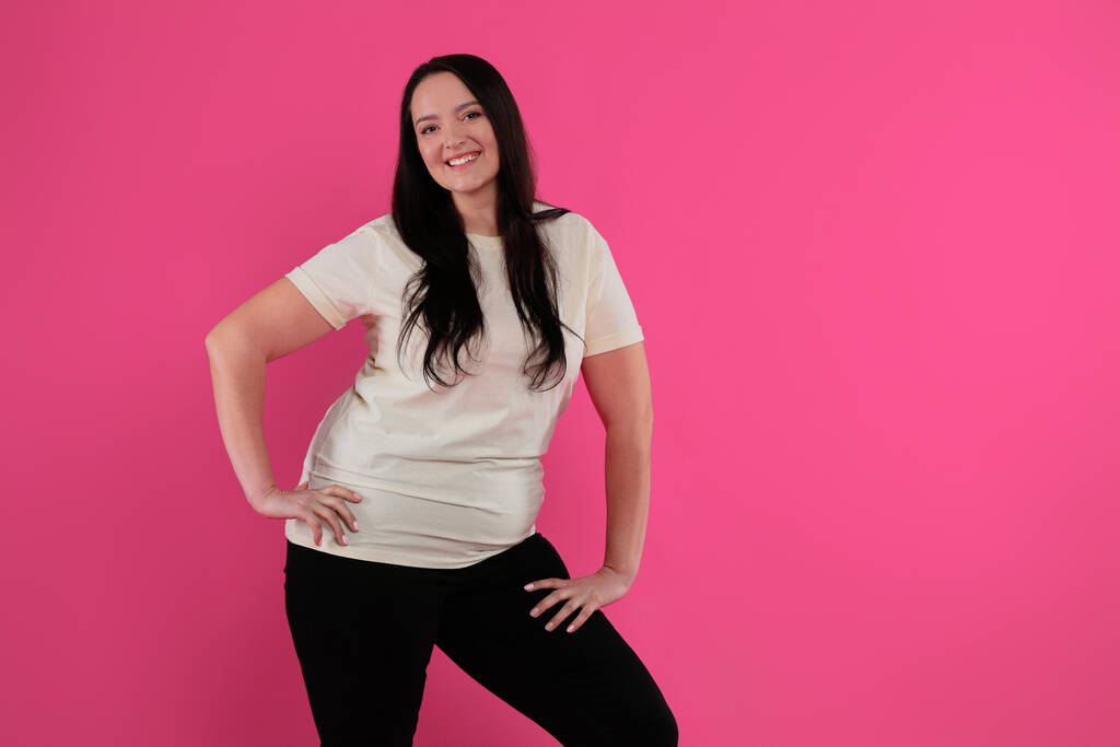 Schöne übergewichtige Frau mit charmantem Lächeln auf rosa Hintergrund. Raum für Text - Foto, Bild