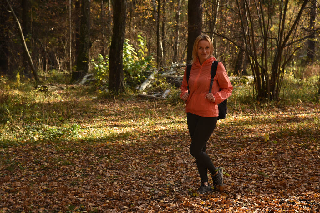 Женщина, гуляющая осенью в лесу - Фото, изображение