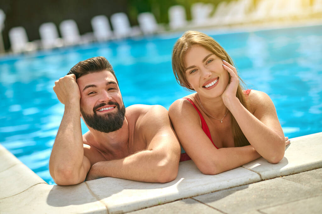 男と女笑顔でカメラでプール - 写真・画像