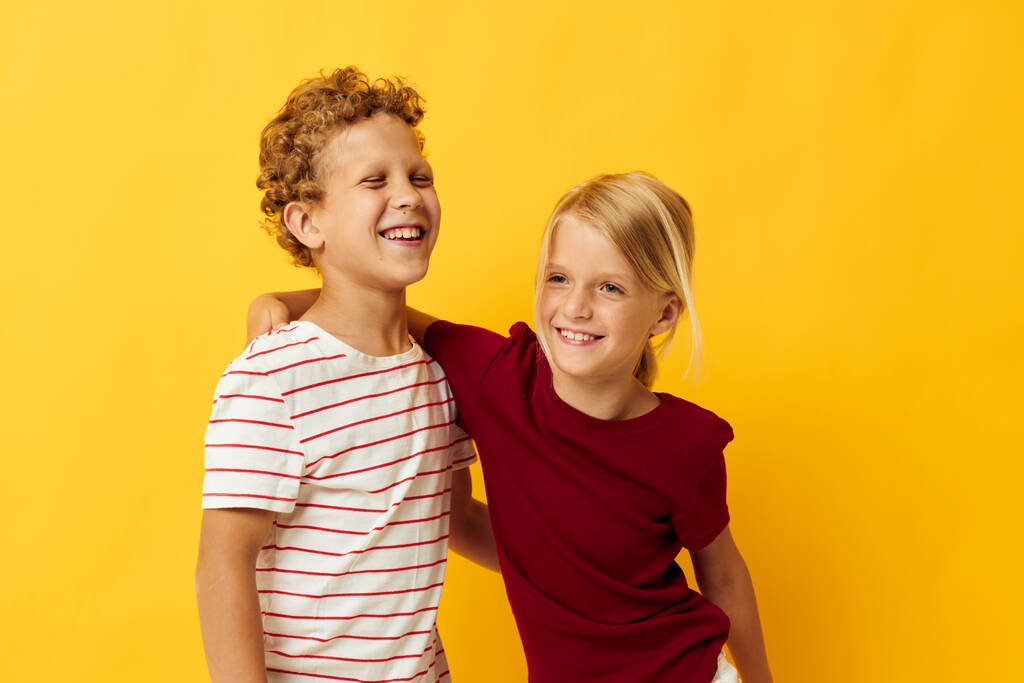 Χαριτωμένο κομψά παιδιά στέκεται δίπλα-δίπλα ποζάροντας παιδικά συναισθήματα κίτρινο φόντο - Φωτογραφία, εικόνα