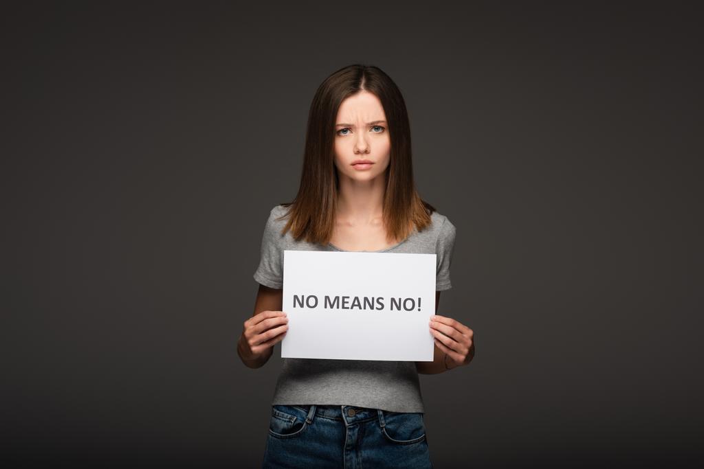 young and serious woman holding card with no means no lettering isolated on grey - Photo, Image