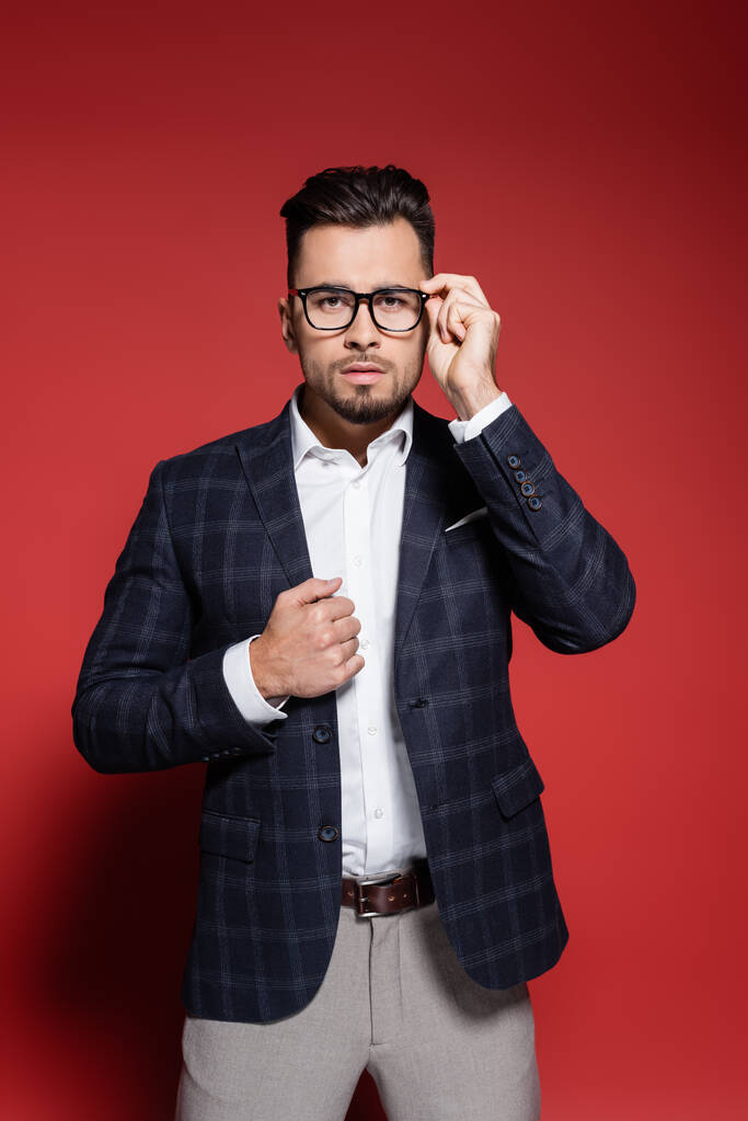 uomo d'affari barbuto in abito scozzese occhiali di regolazione sul rosso - Foto, immagini