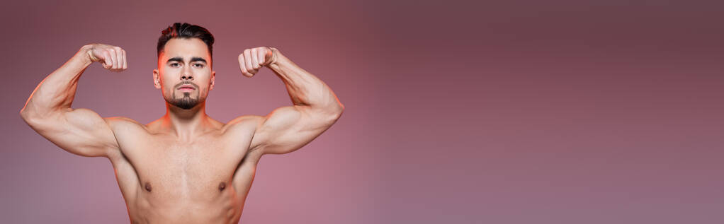 Beleuchtung eines starken Mannes mit Muskeln in rosa und grau, Banner - Foto, Bild