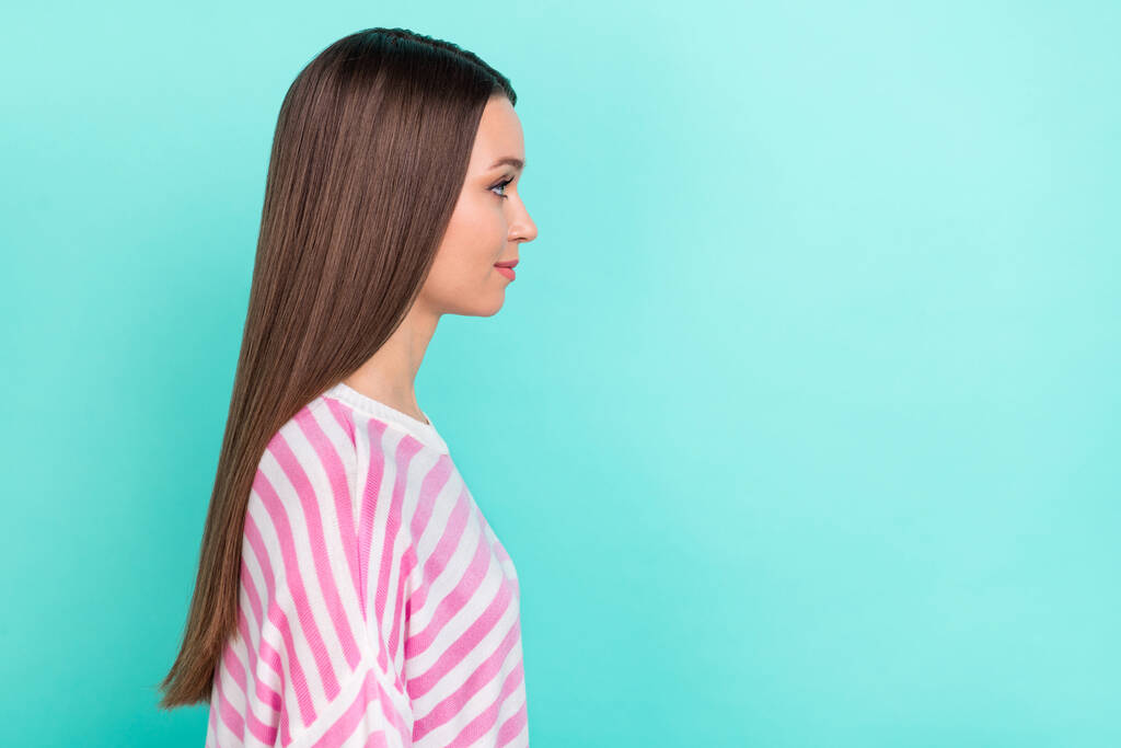 プロフィールサイドビューポートレートの魅力的な甘い柔らかいブルネットの女の子のコピースペース広告隔離された明るいティールターコイズ色の背景 - 写真・画像