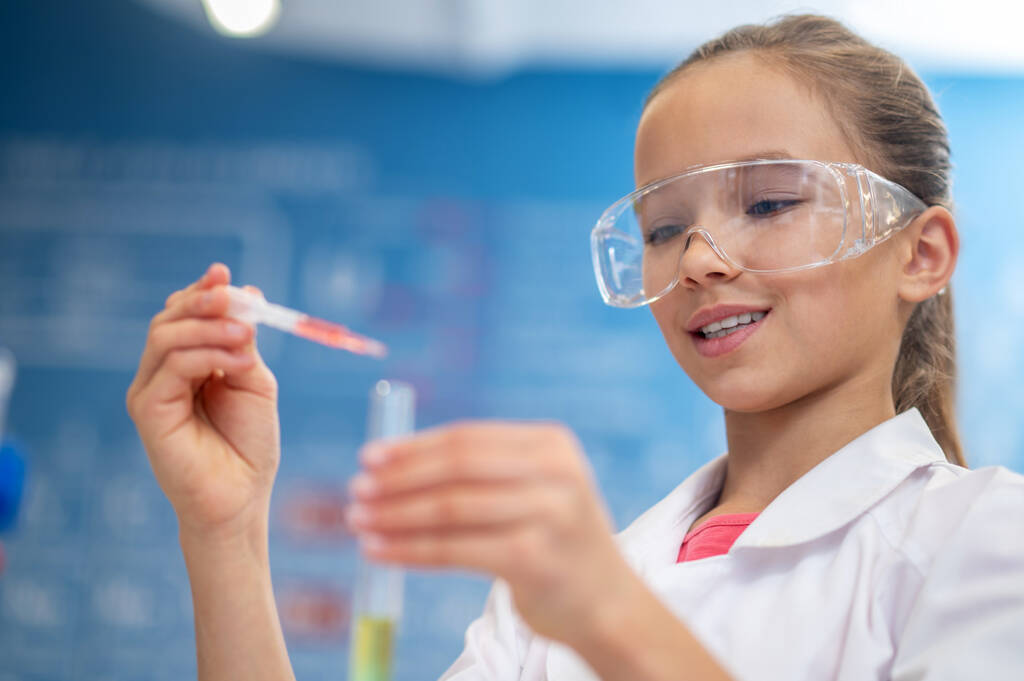 Girl adding liquid from pipette to test tube - Photo, Image