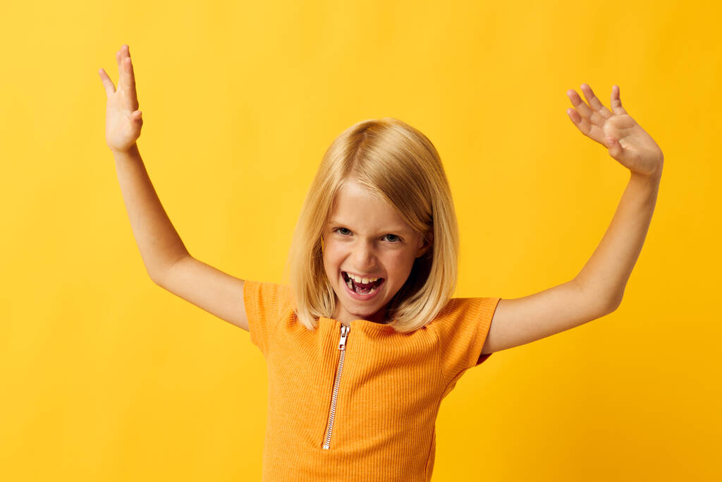 iloinen pieni tyttö käsi ele ja hauska keltainen tausta - Valokuva, kuva
