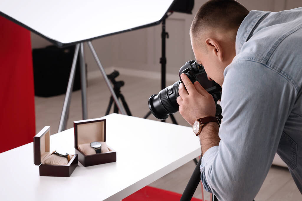 Fotógrafo profesional tomando fotos de relojes de pulsera caros en el estudio - Foto, imagen