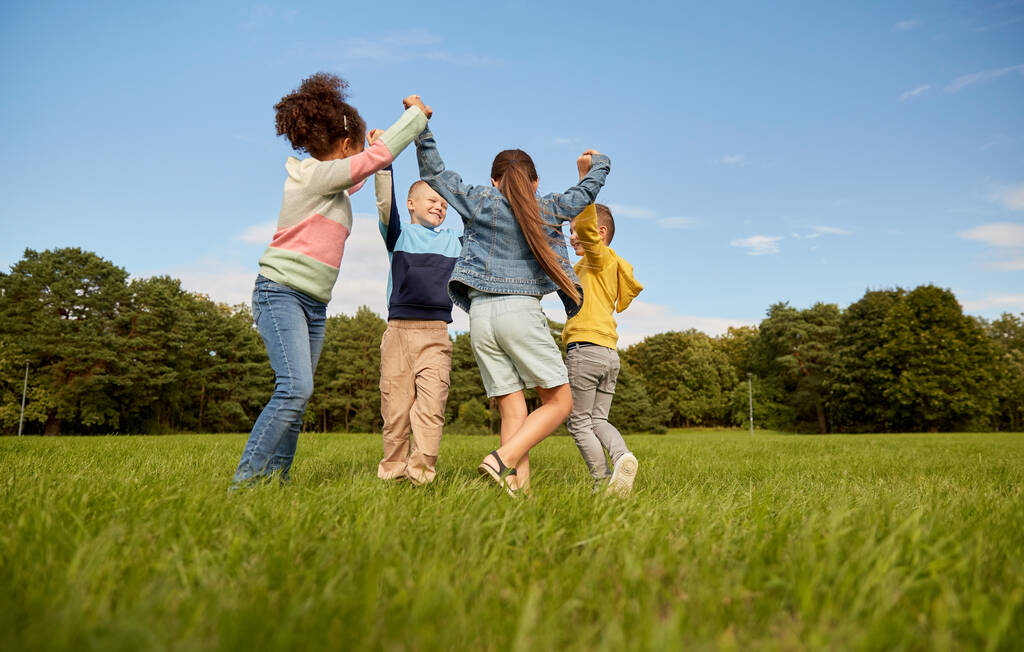 niños felices jugando danza redonda en el parque - Foto, Imagen