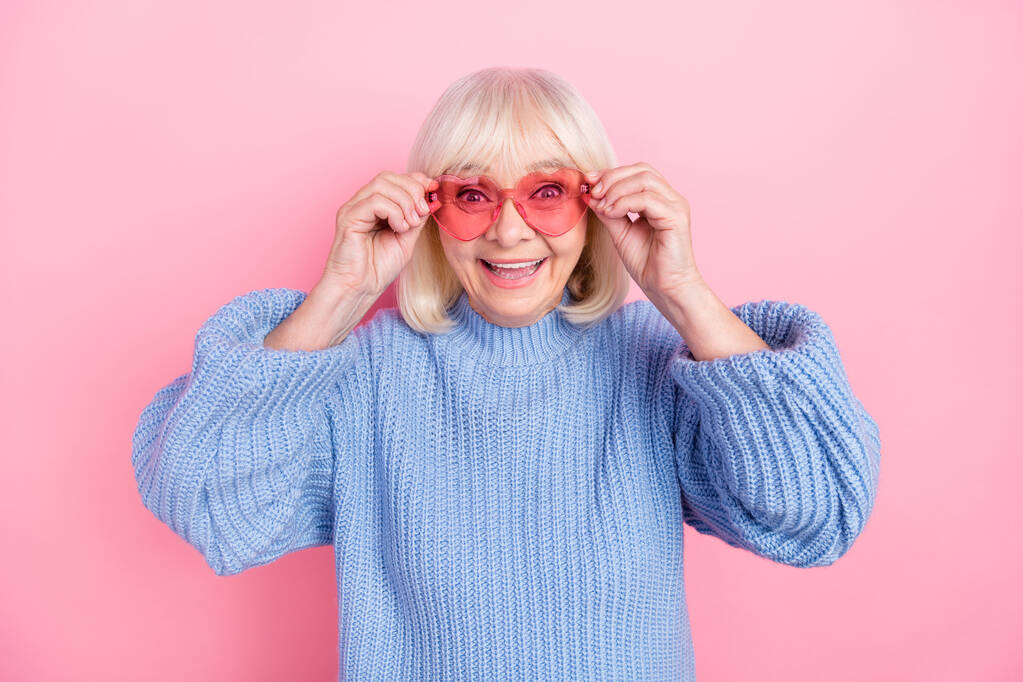 Portrait of attractive funky cheerful grey-haired woman touching spectacles isolated over pink pastel color background - Photo, Image