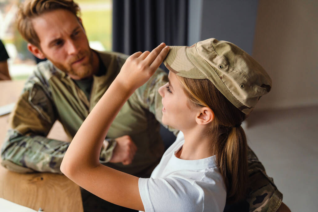 Erkeksi asker evde gülümseyen kızıyla konuşuyor. - Fotoğraf, Görsel