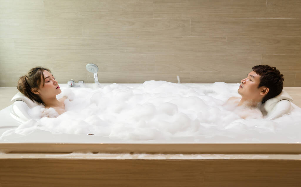 jovem casal relaxante em tubo de banho com os olhos fechados no banheiro - Foto, Imagem