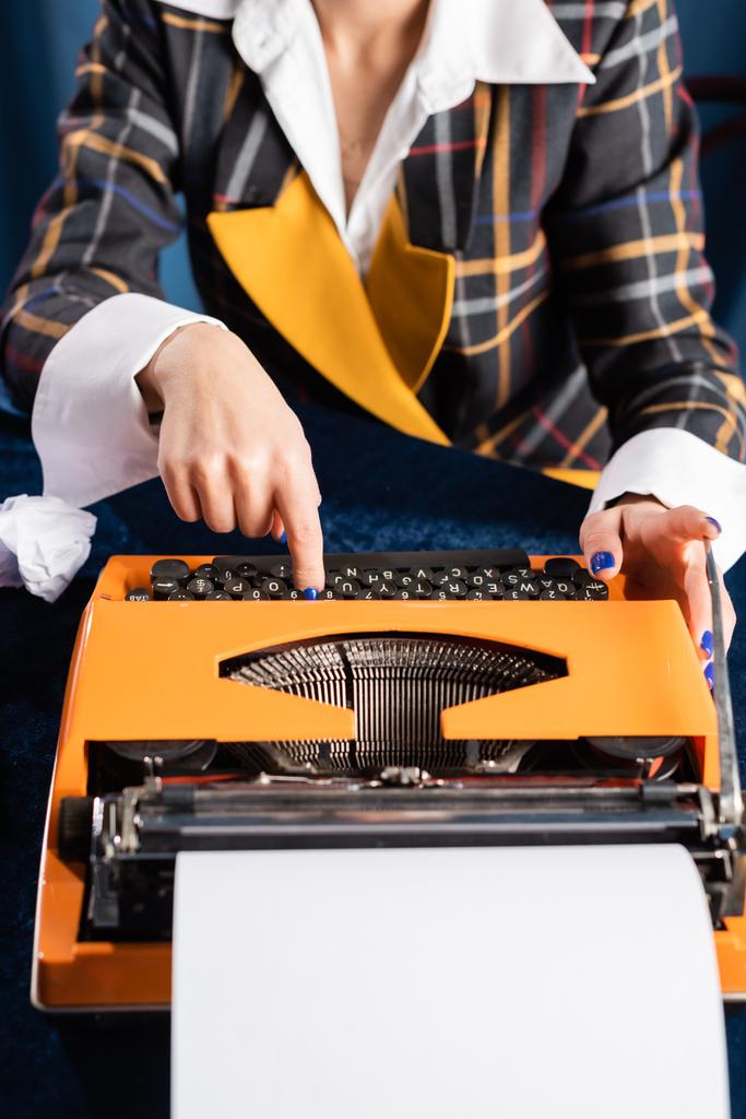 vista recortada de la reportera en elegante chaqueta de escribir en la máquina de escribir vintage  - Foto, imagen