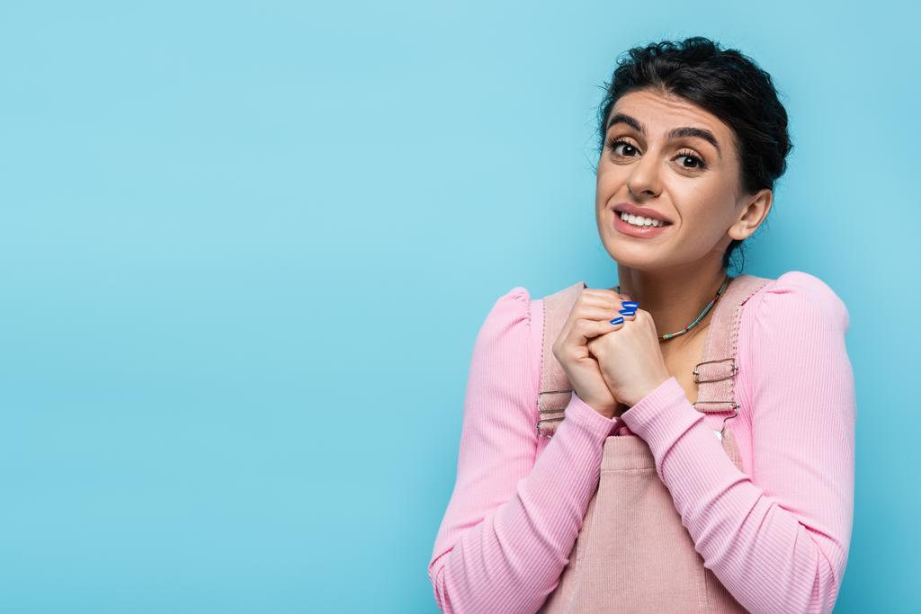 smiling woman showing please gesture while looking at camera isolated on blue - Photo, Image