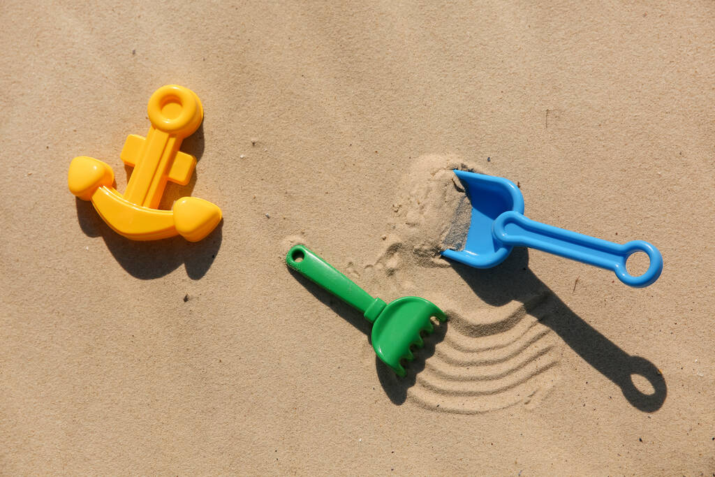 Набор пластиковых пляжных игрушек на песке, плоский уголок. Игра на открытом воздухе - Фото, изображение