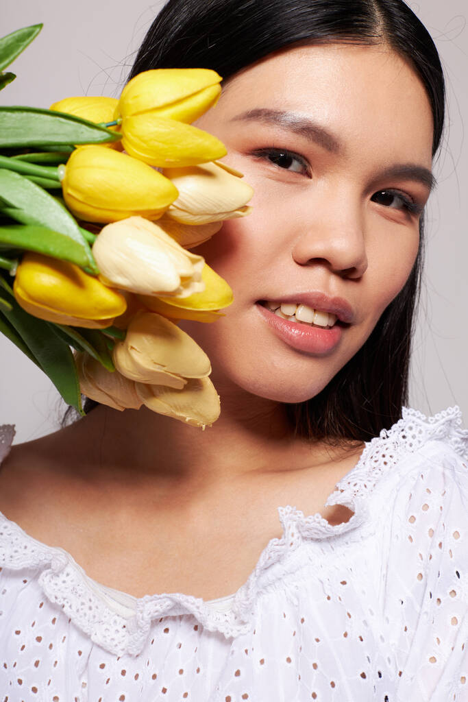 Frau mit asiatischem Aussehen Blumen Frühling posiert Licht Hintergrund unverändert - Foto, Bild