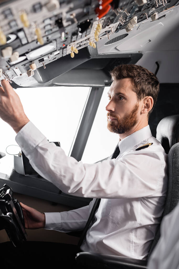 piloto barbudo atingindo painel suspenso ao usar o jugo no simulador de avião - Foto, Imagem