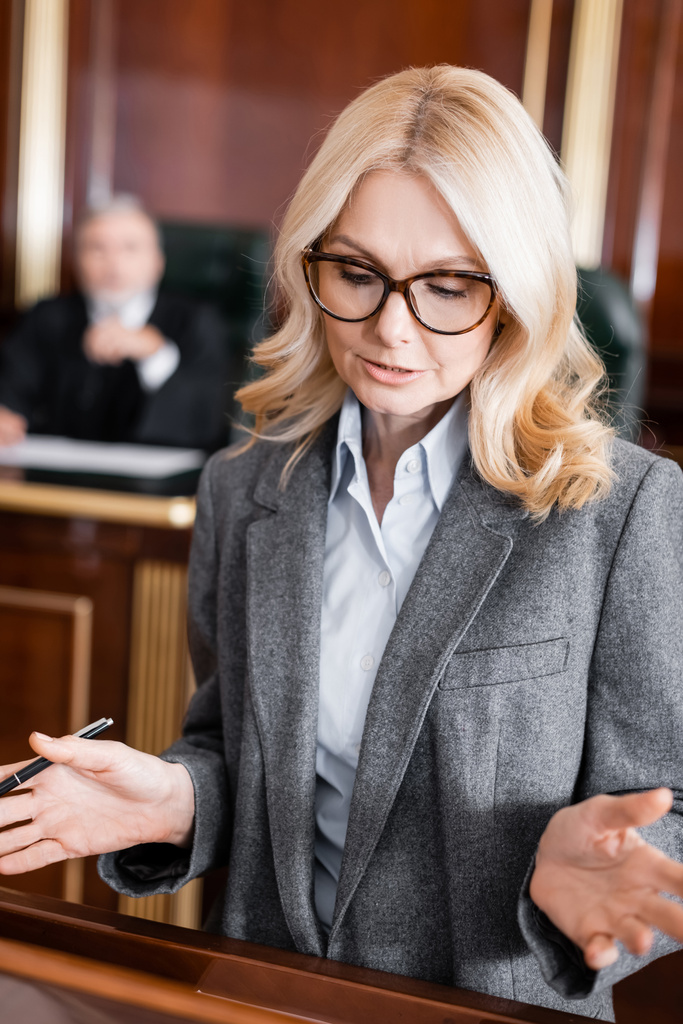 блондинка захисник в окулярах жестикулює під час промови в суді
 - Фото, зображення