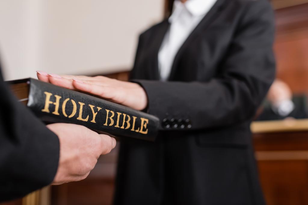 vue recadrée de femme floue donnant jurer sur la bible pendant le litige - Photo, image