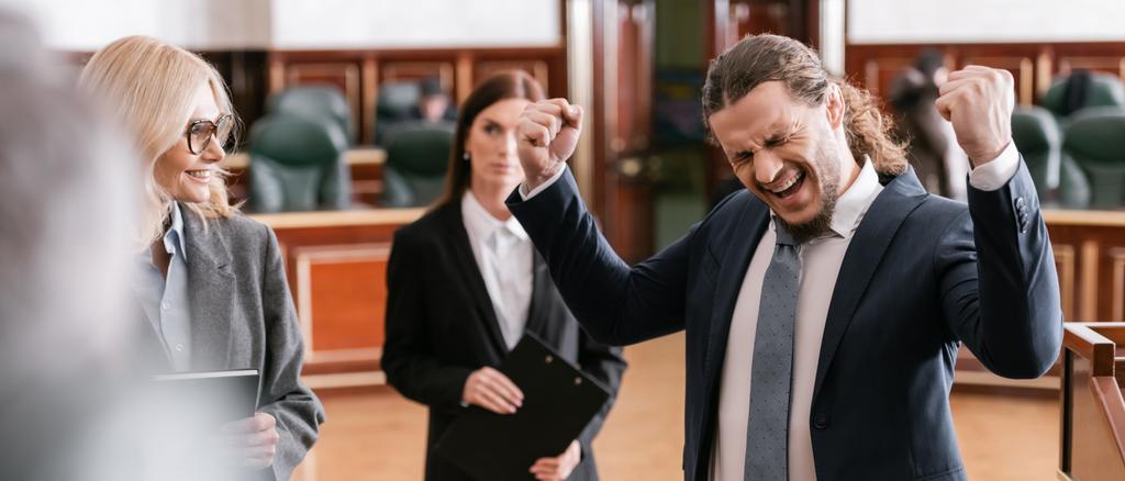 feliz hombre de negocios justificado gritando mientras que muestra el gesto de ganar en la corte, bandera - Foto, Imagen