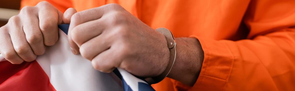 ウサ・フラグ正義の概念バナーを引き裂く手錠の有罪判決を受けた男の部分的な見解 - 写真・画像