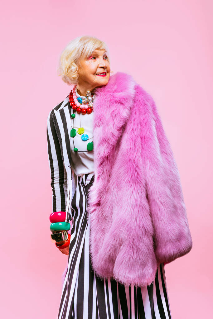 色の背景にファッショナブルな服の肖像画と幸せと面白いクールな老婦人-豪華なスタイル、ライフスタイル、年功序列と高齢者に関する概念を持つ若い祖母 - 写真・画像