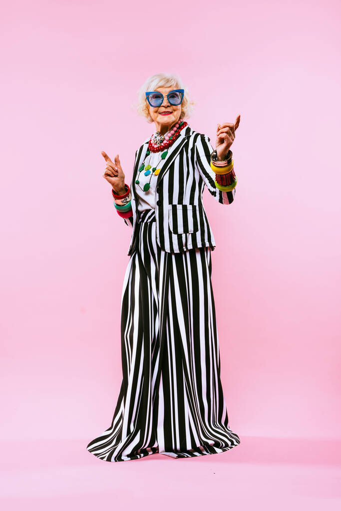 Feliz y divertida señora de edad fresca con retrato de ropa de moda sobre fondo de color - Abuela joven con estilo extravagante, conceptos sobre el estilo de vida, la antigüedad y las personas mayores - Foto, imagen