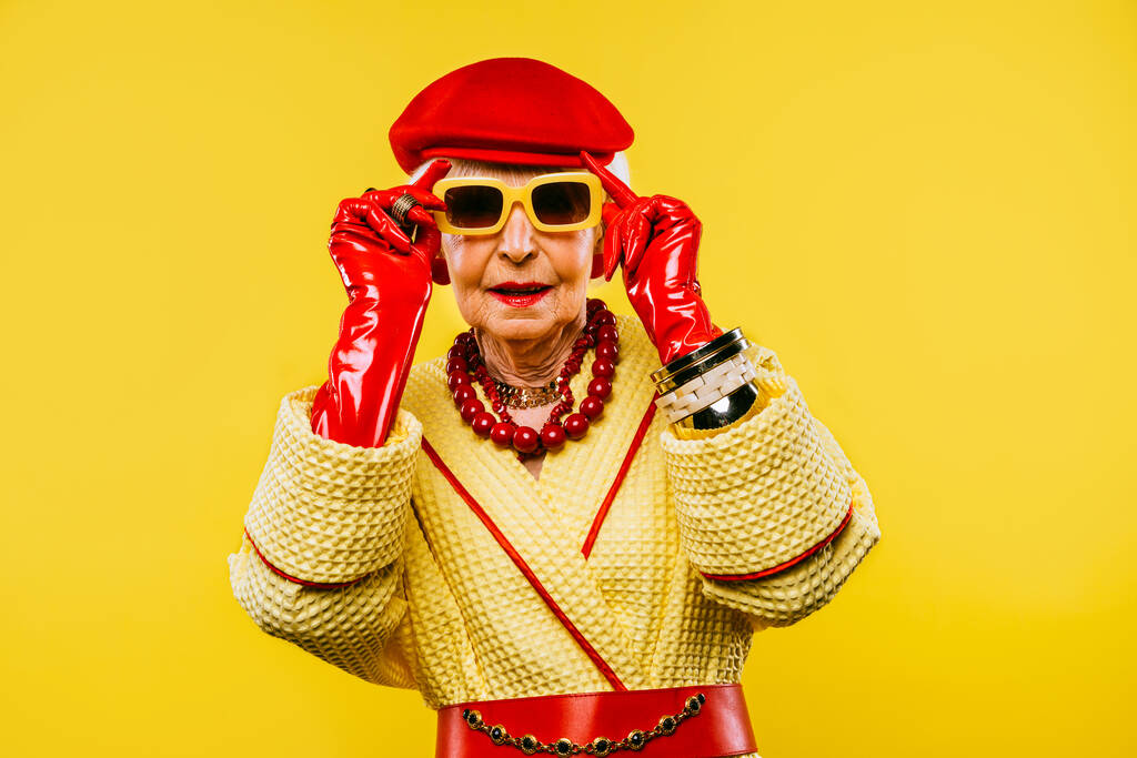 Szczęśliwy i zabawny chłodny starsza pani z modnym portretem ubrania na kolorowym tle - Młodzieńcza babcia z ekstrawaganckim stylu, koncepcje o stylu życia, starszeństwa i osób starszych - Zdjęcie, obraz