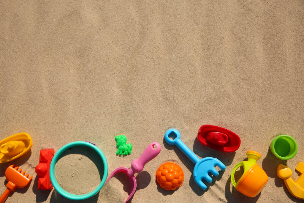 Strandspielzeug aus Plastik auf Sand, flach liegend mit Platz für Text. Spiel unter freiem Himmel - Foto, Bild