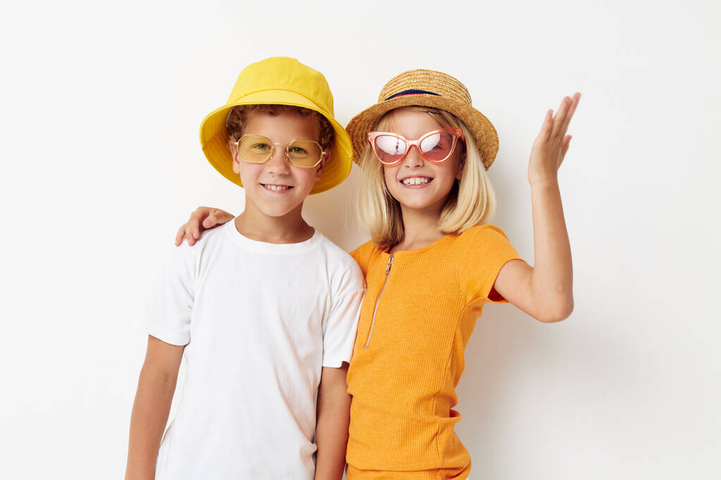 αστείο αγόρι και κορίτσι φορώντας καπέλα που θέτουν φως μόδας φόντο - Φωτογραφία, εικόνα