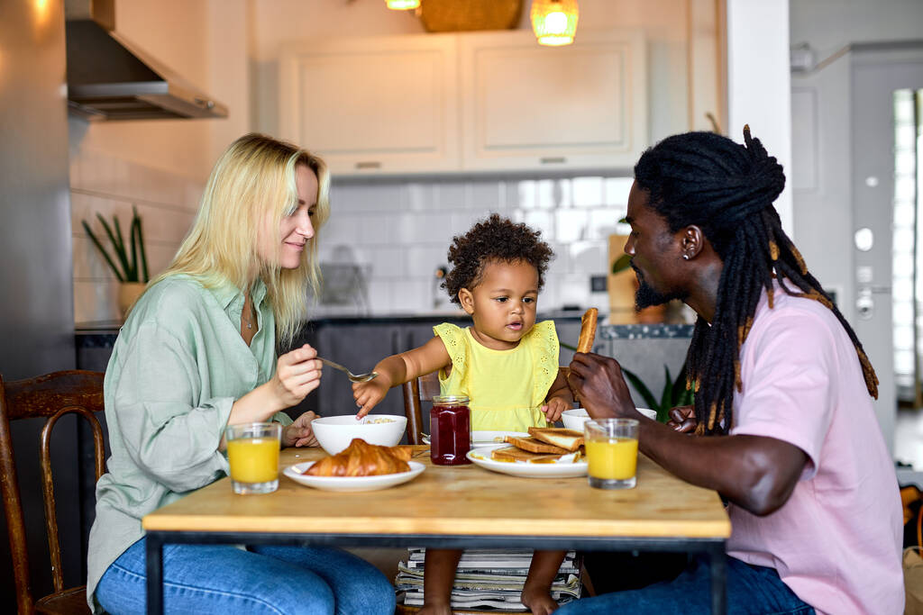 Piękna rodzina je razem śniadanie, cieszyć się posiłkiem w domu w kuchni, rano - Zdjęcie, obraz