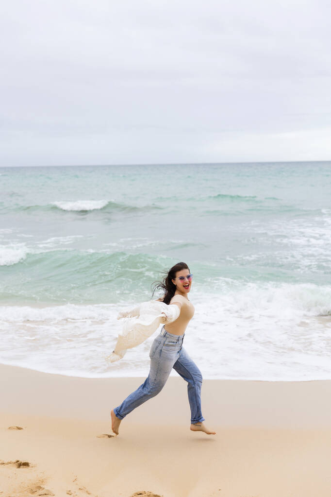 joven hermosa chica divirtiéndose en la playa de Portugal en el contexto del Océano Atlántico - Foto, Imagen