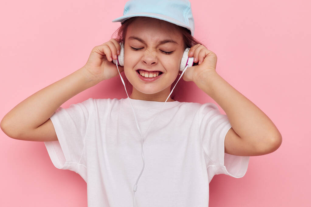 κοριτσάκι ακούγοντας μουσική σε ακουστικά απομονωμένο φόντο - Φωτογραφία, εικόνα