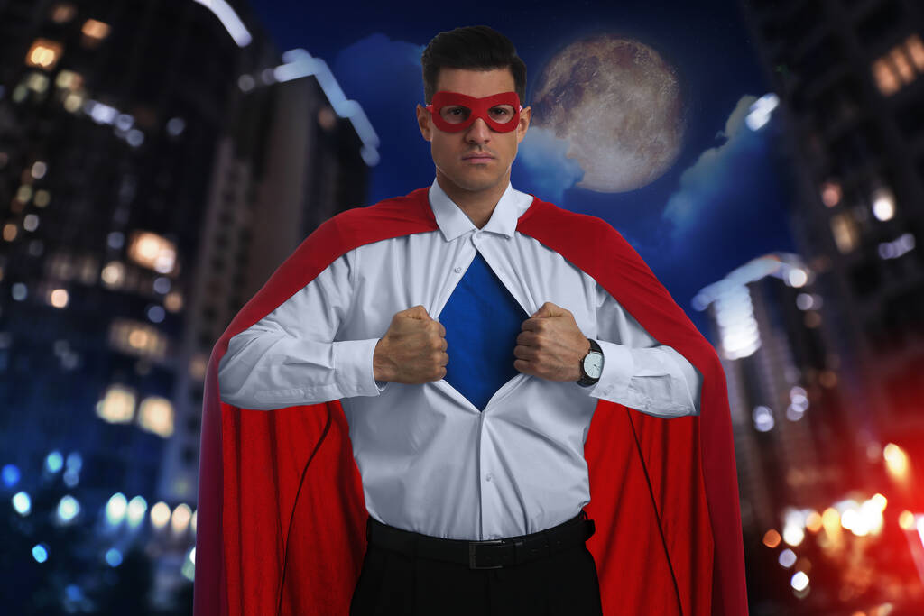Süper kahraman kostümü giyen bir iş adamı ve arka planda güzel bir şehir manzarası - Fotoğraf, Görsel
