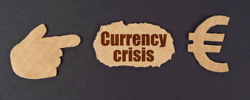 Σε μια μαύρη επιφάνεια, μια φιγούρα ενός χεριού, ένα σύμβολο του ευρώ και ένα σκισμένο χαρτόνι με την επιγραφή - νομισματική κρίση - Φωτογραφία, εικόνα