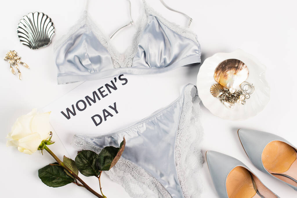 Vista dall'alto di lingerie, carta con lettering giorno delle donne e tacchi su sfondo bianco  - Foto, immagini