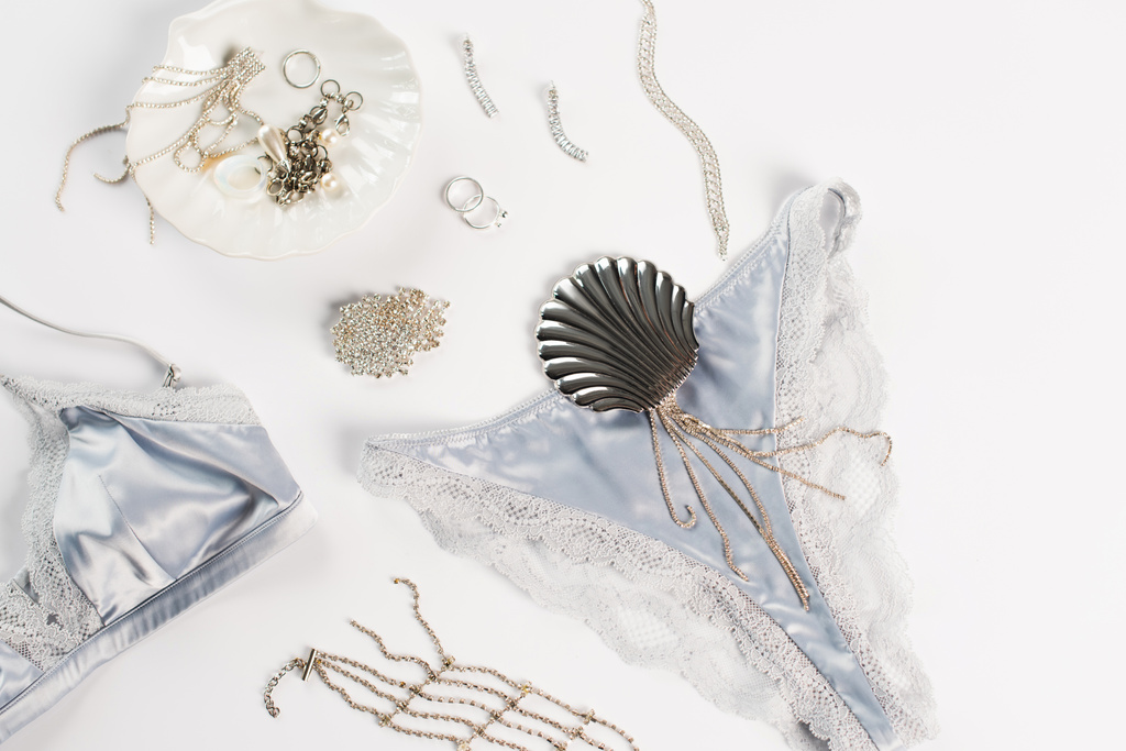 Vista dall'alto di lingerie di seta e accessori su sfondo bianco  - Foto, immagini