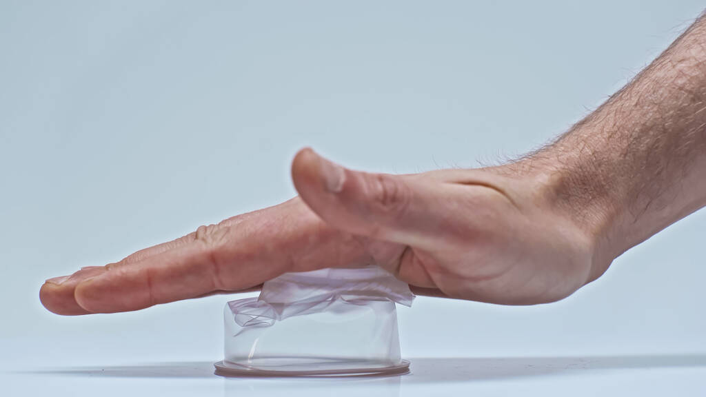 vue partielle de l'homme appuyant sur la tasse en plastique sur gris, concept zéro déchet - Photo, image