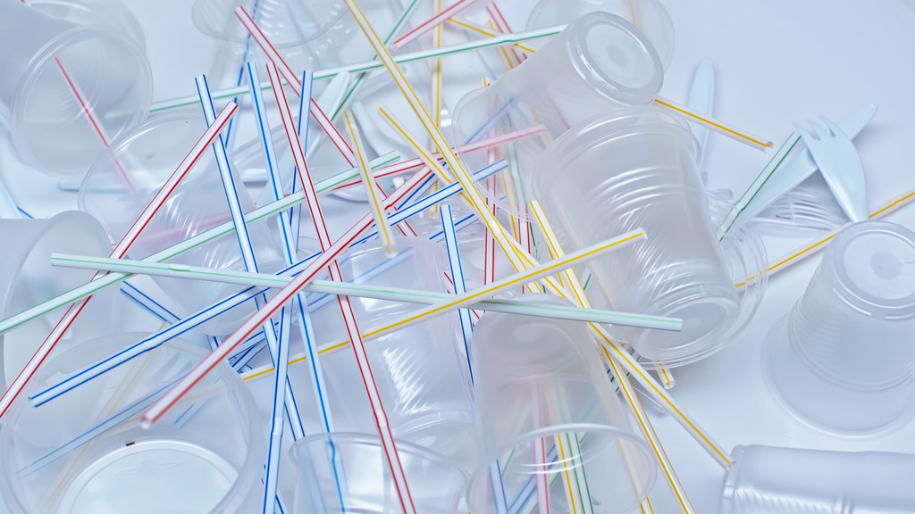 високий кут зору пластикових чашок біля виделки і барвисті соломинки на білому
 - Фото, зображення