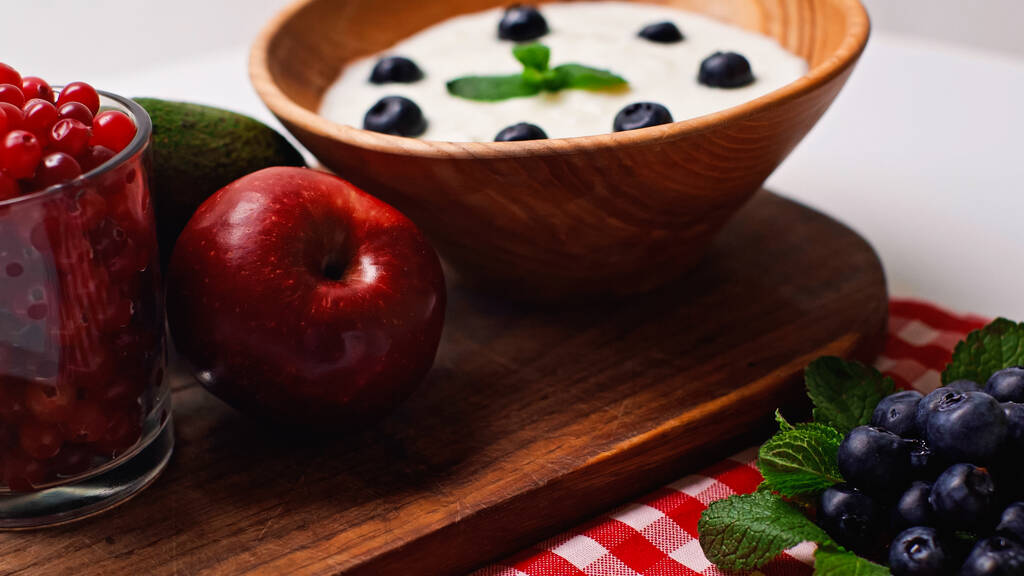 Taze meyve, nane şekeri ve beyaz yoğurtlu ahşap kasenin yanında böğürtlen. - Fotoğraf, Görsel