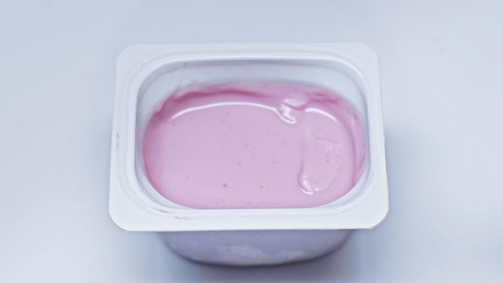 vista superior del recipiente de plástico con yogur rosa sobre blanco - Foto, Imagen