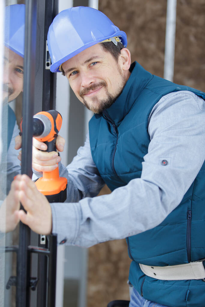 portrait of happy man holding his drill - Photo, Image