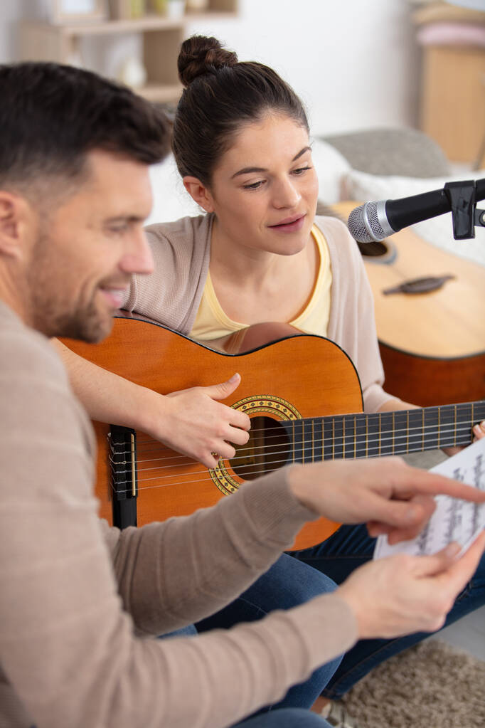 musicien enseigne aux étudiantes comment jouer de la guitare - Photo, image