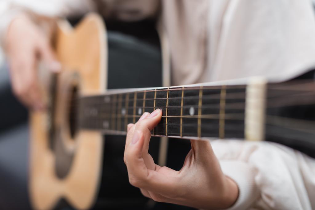 vista parcial de una joven tocando la guitarra acústica - Foto, Imagen