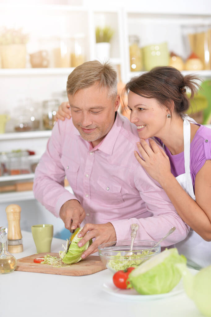 pareja haciendo ensalada en la cocina en casa - Foto, imagen